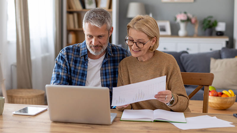 Casal com papéis e computador